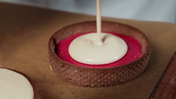 Chef toevoegen van witte room aan de kleine taartjes met chokolaat — Stockvideo