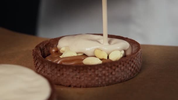 Chef adicionando creme branco para as pequenas tortas amendoins — Vídeo de Stock