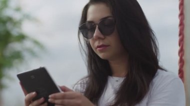 Sokakta bir kız e-kitap okuyor.