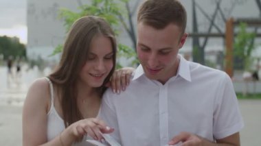 Açık havada bir adam ve bir kız bir e-kitap okudu.