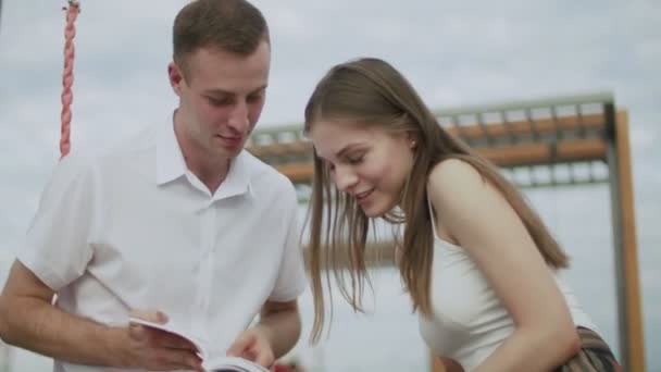 Un mec et une fille en plein air ont lu un e-book — Video