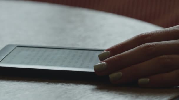 E-book sul tavolo con una mano femminile primo piano — Video Stock