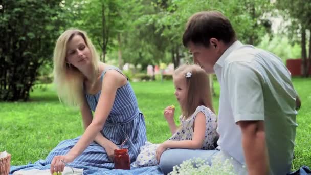 Die Familie arrangierte ein Picknick in der Natur, sie essen Obst und kommunizieren — Stockvideo