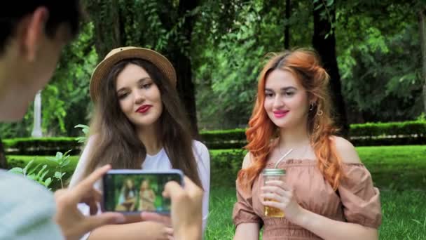 Een man neemt foto 's van meisjes aan de telefoon in de zomer in de natuur, close-up — Stockvideo