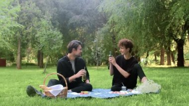 Yazın doğada bir adam başka bir adamla telefonda fotoğraf çekiyor.