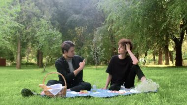 Yazın doğada bir adam başka bir adamla telefonda fotoğraf çekiyor.