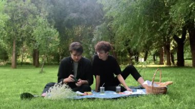 Adam telefonda oyun oynuyor, ikincisi ise yazın doğadaki süreci izliyor.