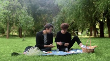 Adam telefonda oyun oynuyor, ikincisi ise yazın doğadaki süreci izliyor.