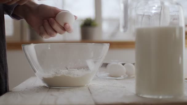 De chef breekt een ei met een mes. — Stockvideo