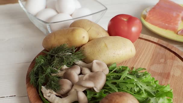 Las verduras están tumbadas en una tabla de madera en la cocina — Vídeo de stock