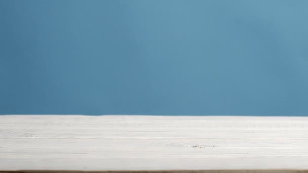 Грибы ролл на белом деревянном столе на синем фоне — стоковое видео