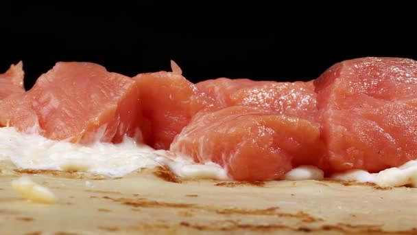 Pannenkoek met rode vis en witte saus op tafel op een zwarte achtergrond — Stockvideo