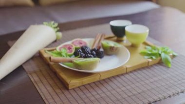 Ahşap tepside mis kokulu yeşil çay tabağında lezzetli meyve tabağı.