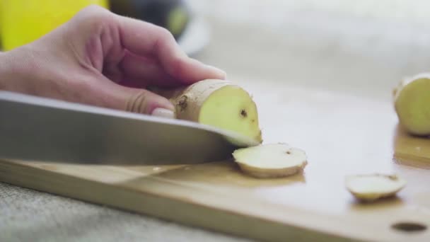 Cortar raíz de jengibre fresca en un primer plano de tabla de cortar de madera — Vídeos de Stock