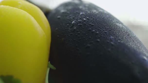 De aubergine wordt met water besproeid en de waterdruppels stromen van dichtbij naar beneden. — Stockvideo
