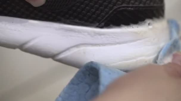 Uma mulher limpa ténis sujos de sola branca com uma esponja — Vídeo de Stock