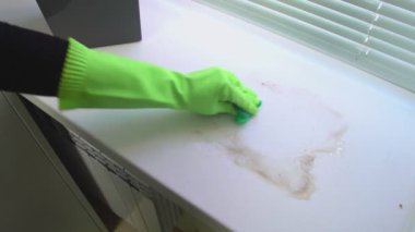 Bir el pencere pervazındaki kiri bir bez parçasıyla siler.