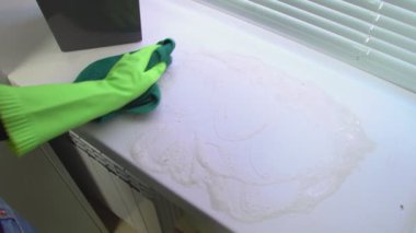 Bir el pencere pervazındaki kiri bir bez parçasıyla siler.