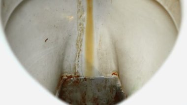 Temizlikçi banyoya deterjan döker.