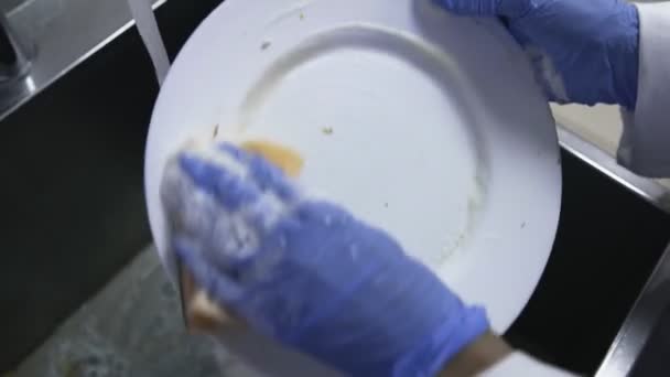 Tvättfat i diskhon med tvättmedel och en svamp i köket — Stockvideo