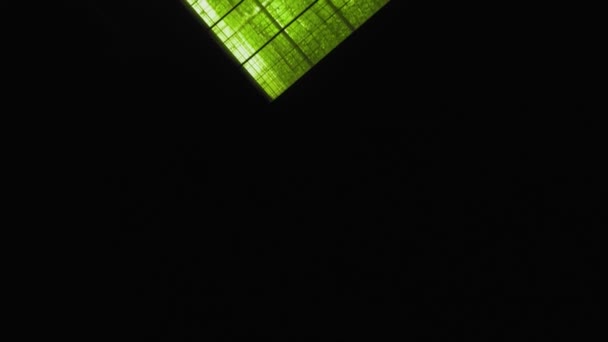 Abstract green geometric background. Illuminated greenhouses at night. Agricultural infrastructure on glass roofs. — Stock Video