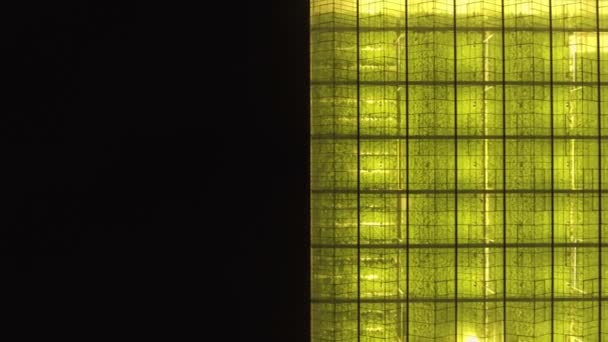 Fondo geométrico verde abstracto. Invernaderos iluminados por la noche. Infraestructura agrícola en techos de vidrio. — Vídeo de stock