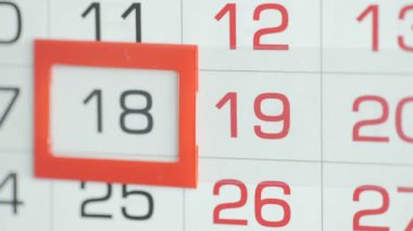 Bir kadının parmağı takvimdeki tarih işaretçisini hareket ettirir