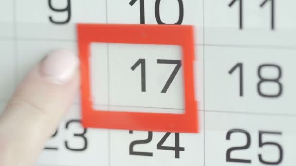 Κοντινό πλάνο ενός γυναικείου δαχτύλου κινεί το δείκτη ημερομηνίας στο ημερολόγιο — Αρχείο Βίντεο