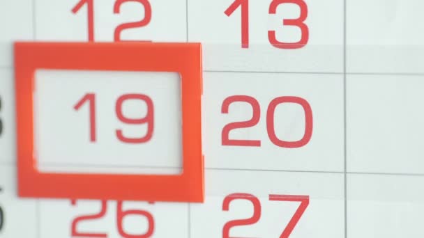 Крупный план женского пальца перемещает указатель даты в календаре — стоковое видео