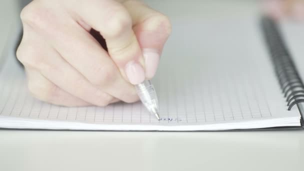 Een onherkenbare zakenvrouw schrijft zakelijke ideeën en plannen op in een notebook om een to-do lijst te maken, close-up — Stockvideo