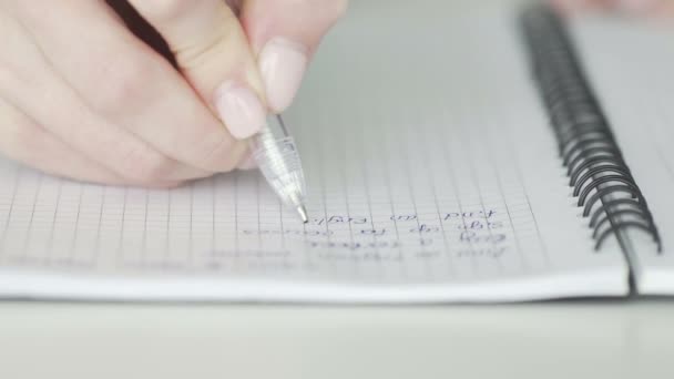 Een onherkenbare zakenvrouw schrijft zakelijke ideeën en plannen op in een notebook om een to-do lijst te maken, close-up — Stockvideo