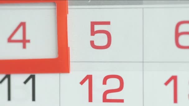 Close-up of a womans finger moves the date pointer on the calendar — Stock Video