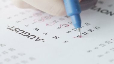 Takvimdeki numaralar yakın plan kırmızı kalemle işaretlenmiş.