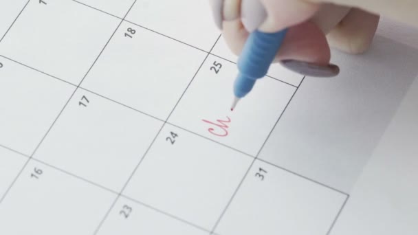 La parola Natale è scritta in una penna rossa in un calendario ravvicinato — Video Stock