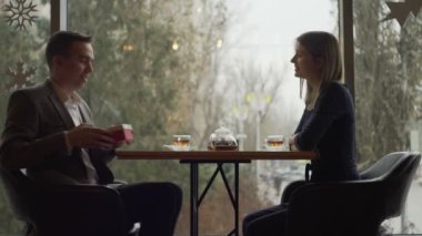 Bir erkek ve bir kadın bir kafede ya da restoranda karşılıklı oturup iletişim kurarlar. Kafede ya da restoranda bir randevu. Romantik atmosfer