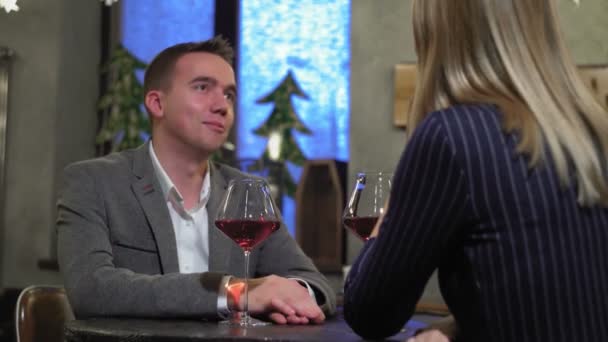 Een man op een date met een vrouw in een café of restaurant die wijn drinkt van dichtbij — Stockvideo