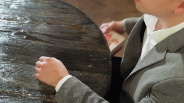 A man takes a gift box from under the table and puts it on the table in a cafe or restaurant close-up — Stock Video