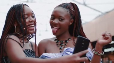 İki güzel Afrikalı kızın telefonda fotoğrafının çekildiği yakın plan.