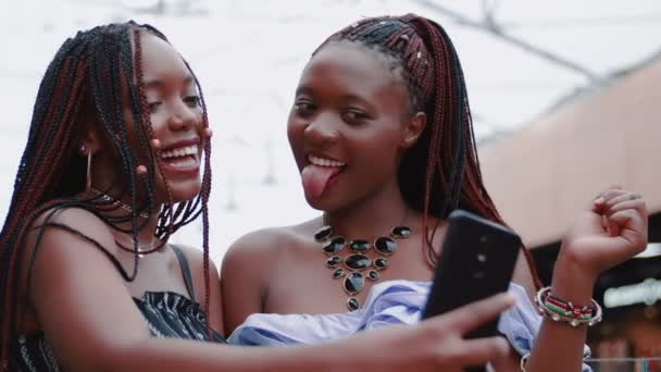 По телефону фотографують двох прекрасних африканських дівчат. — стокове відео