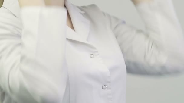 医生的特写穿着医用长袍的妇女把听诊器放在脖子上 — 图库视频影像