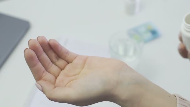 Zbliżenie nierozpoznawalnej kobiety, pacjenta, trzymającego słoik pigułek i wlewającego je w jej dłoń — Wideo stockowe