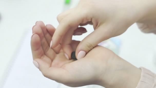 Una ragazza irriconoscibile prende pillole dalla sua mano e le lava con acqua, primo piano — Video Stock