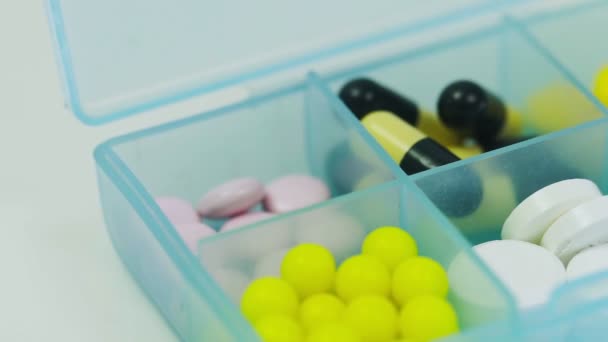 Närbild av en pillerask med olika tabletter i varje cell — Stockvideo