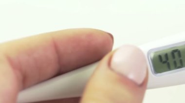 Kadınların ellerinde elektronik termometre, yüksek vücut sıcaklığı ve yakın çekim var.