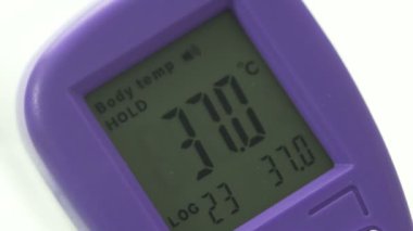 Kadınların ellerinde elektronik termometre, yüksek vücut sıcaklığı ve yakın çekim var.