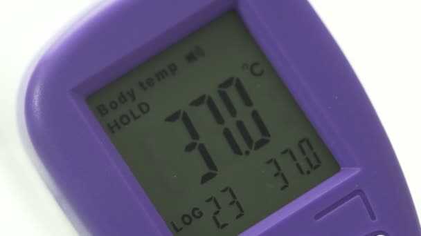 Vrouwen handen houden een elektronische thermometer vast, hoge lichaamstemperatuur, close-up — Stockvideo