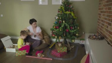 Anne ve çocuk Noel ağacını süslüyor. Noel zamanı. Şenlik havası.