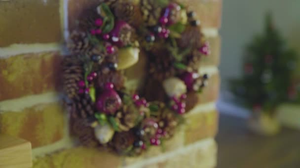 Een prachtige handgemaakte kerstkrans gemaakt van kegels, bessen, bladeren. Kerstmis. — Stockvideo