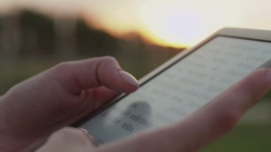 Kadınların elleri e-kitap tutuyor.