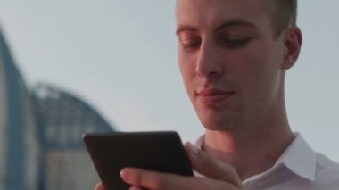 Akşamları sokakta bir adam e-kitap okuyor.